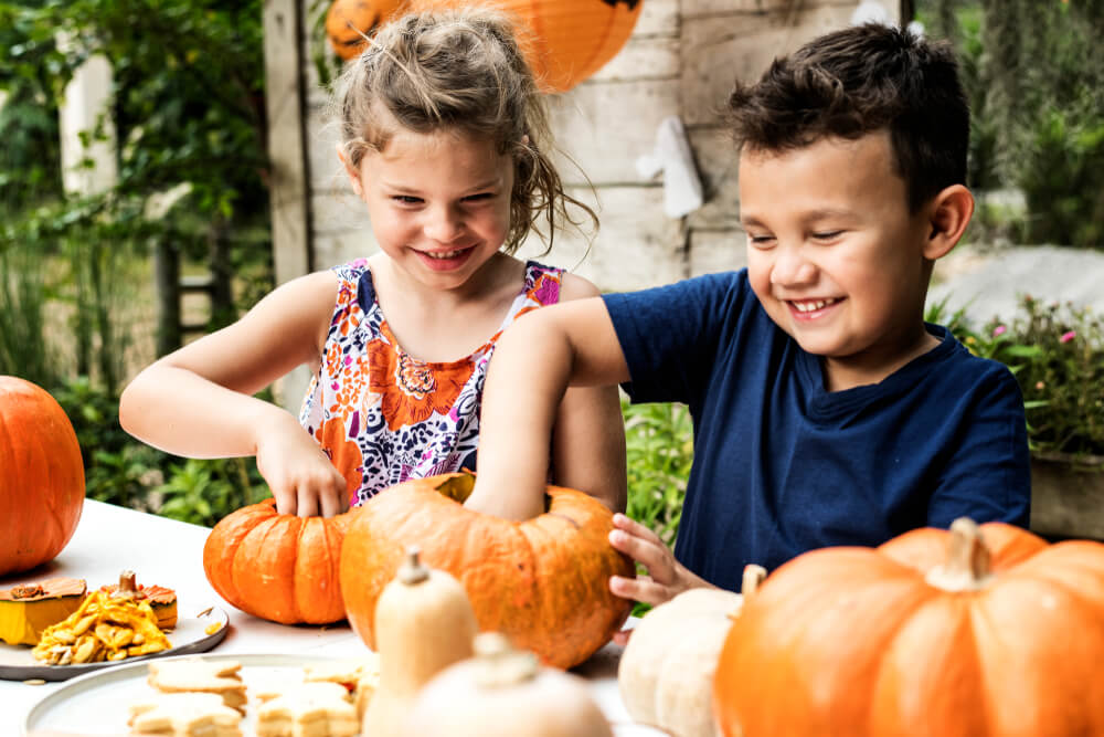 Kids carving a pumpkin and enjoying a fall festival in Tampa Bay Area