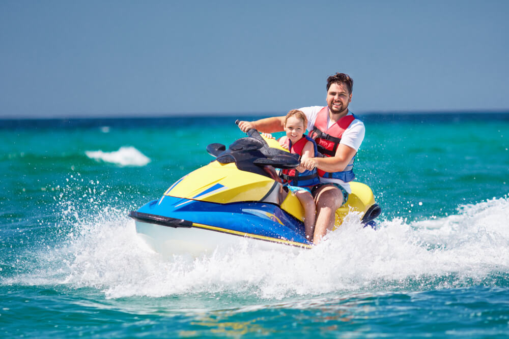 Father and child riding a jet ski in Indian Rocks Beach, one of the top Florida Gulf Coast vacation spots