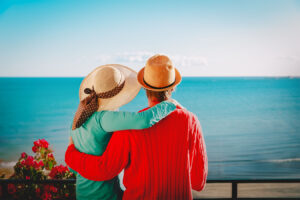 Happy couple overlooking the beach from their balcony.