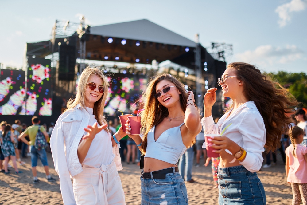 Group of friends holding drinks at an outdoor concert in Tampa Bay