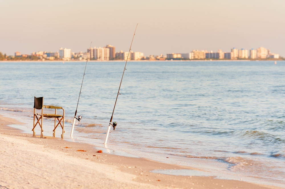 Chair on the beach with two fishing poles on the Gulf Coast of Florida