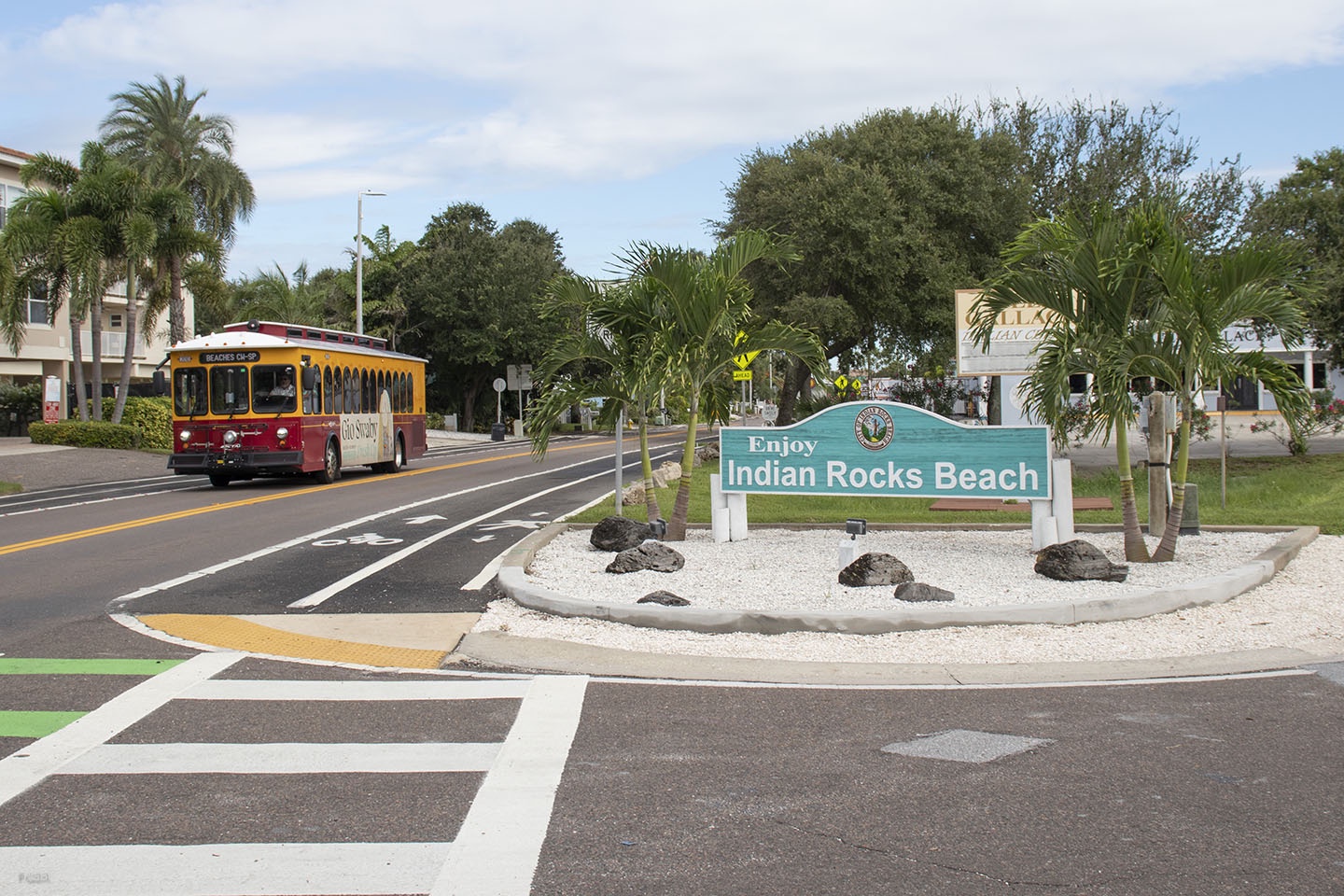 Bus coming down road with sign saying Enjoy Indian Rocks Beach