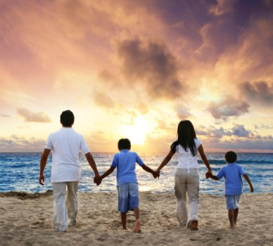 Family holding hands on the beach at sunset | Plumlee Indian Rocks Beach Vacation Rentals