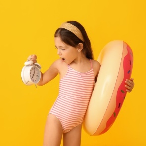 Girl ready for the pool and beach looking at a clock  | Plumlee Indian Rocks Beach Vacation Rentals