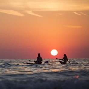 Couple Paddling on Water During Sunset | Plumlee Realty