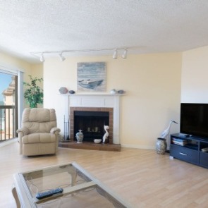 Living room with beach view, fireplace and big-screen TV | Plumlee Gulf Beach Vacation Rentals