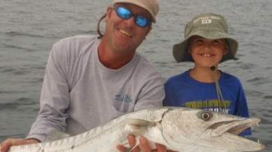 Man and boy holding a big fish | Plumlee Gulf Beach Vacation Rentals