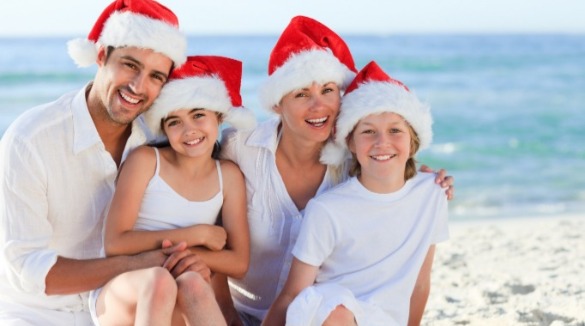 family on the beach wearing Santa hats | Plumlee Vacation Rentals