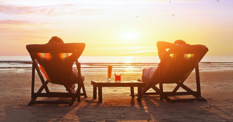 couple relaxing on the beach | Plumlee Realty