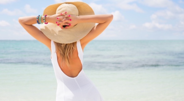 Woman with big floppy sun hat on the beach | Plumlee Indian Rocks Beach vacation rentals