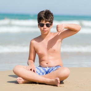 Boy on beach giving a thumb's down  | Plumlee Indian Rocks Beach Condo Rentals