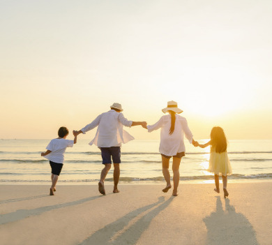 Family holding hands on beach during sunset | Plumlee Indian Rocks Beach Condo Rentals