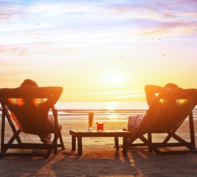 Couple on beach chairs relaxing by the beach | Plumlee Realty Indian Rocks Beach vacation rentals