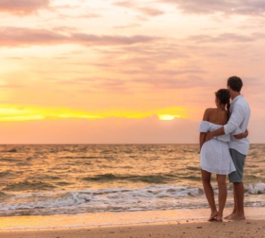 Couple enjoying the sunset on the beach | Plumlee Vacations Indian Rocks Beach Rentals