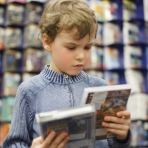 little boy deciding what DVD to watch | Plumlee Gulf Beach Realty