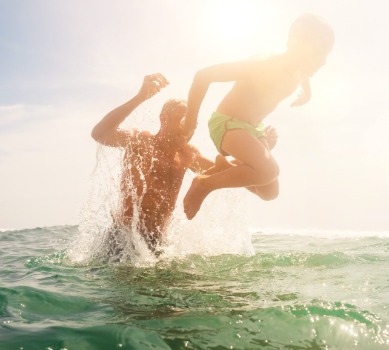 Father and son playing in the ocean | Plumlee Realty Indian Rocks Beach vacation rentals