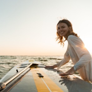 Woman heading out on a paddleboard adventure | Plumlee Indian Rocks Beach Rentals