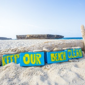 beach with painted rocks that say keep our beach clean | Plumlee Gulf Beach Realty