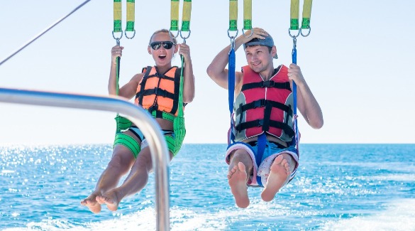 Teenagers parasailing over the Gulf of Mexico | Plumlee Indian Rocks Beach vacation rentals